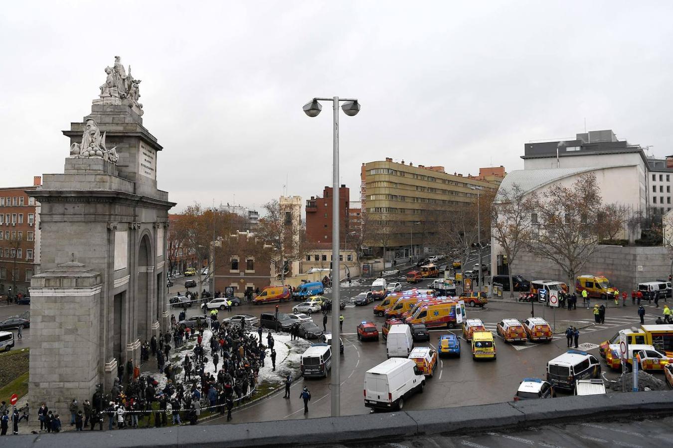Personal de emergencia y periodistas se reúnen en la rotonda de Puerta de Toledo luego de que una fuerte explosión golpeara un edificio en Madrid.