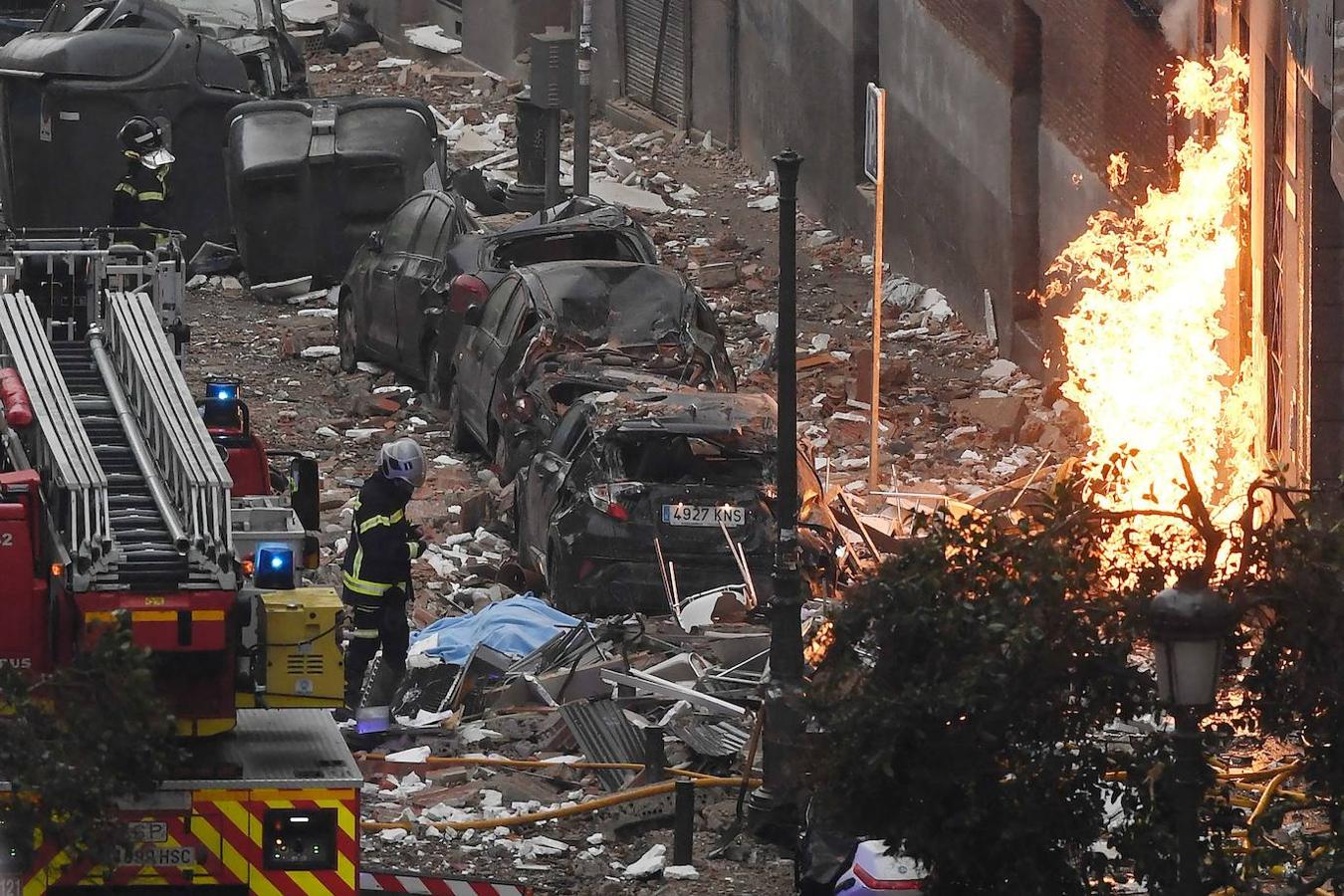 Los bomberos caminan frente a un edificio en Madrid después de que una fuerte explosión lo sacudiera.