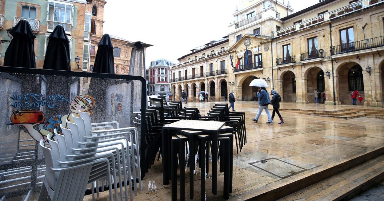 Una terraza hostelera recogida por la lluvia, ayer, en la plaza de la Constitución. 