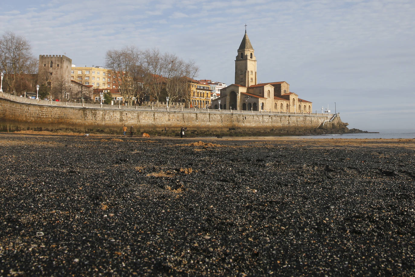 La gijonesa playa de San Lorenzo ha vuelto a amanecer cubierta de carbón, creando una estampa que sigue impactando.