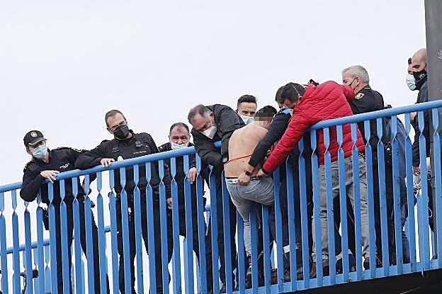 Testigos y policías sujetan al joven en el puente de Moreda. 