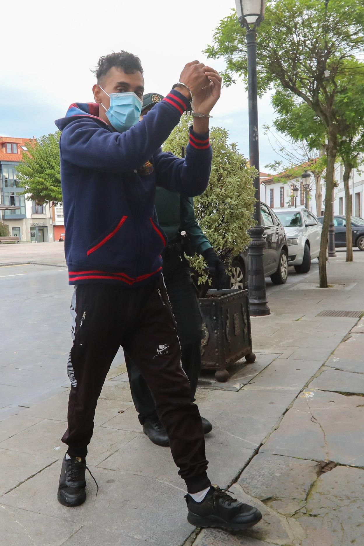 El joven detenido, esposado en los juzgados de Pravia. 