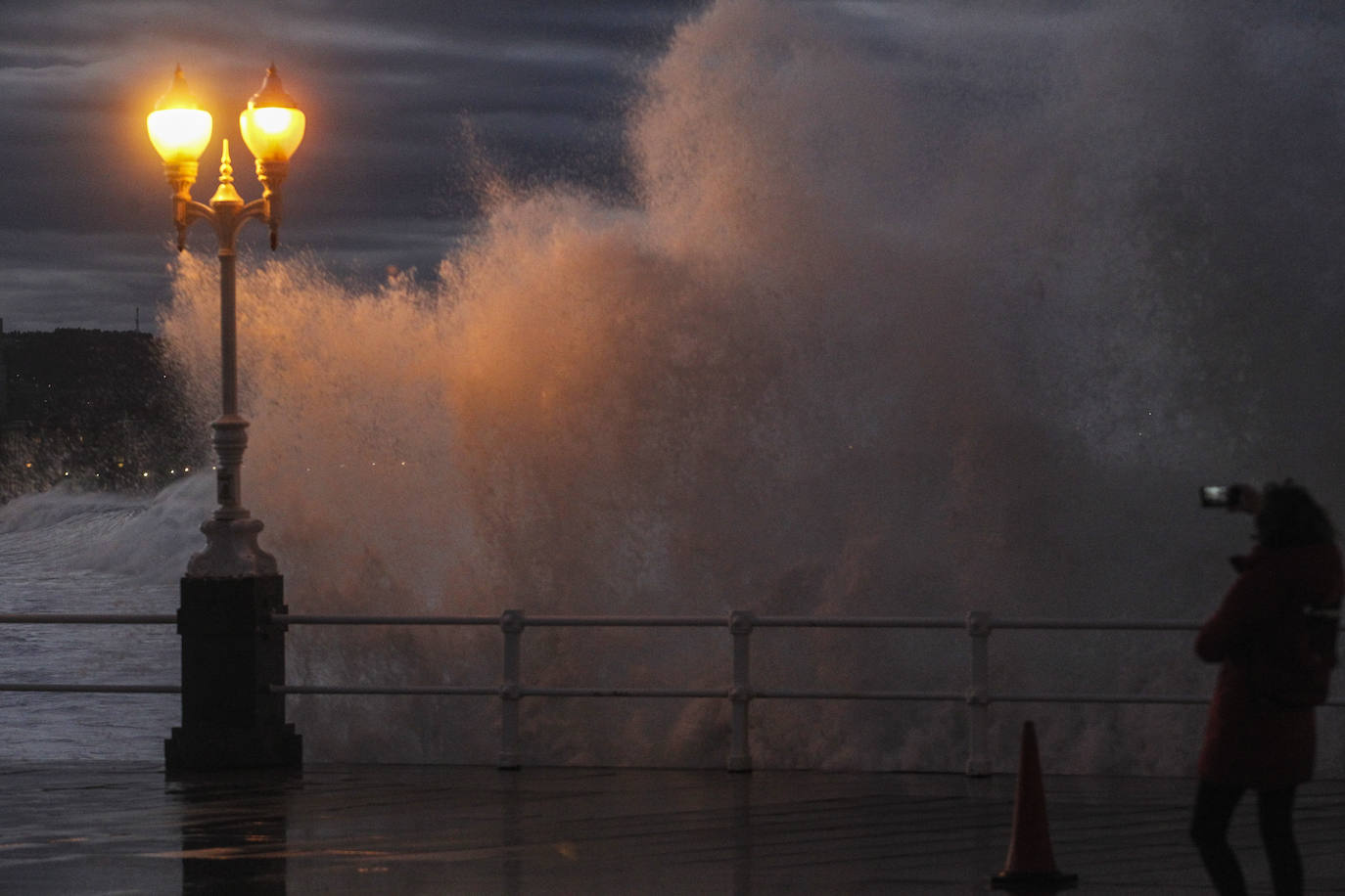 El oleaje que se ha dejado notar este lunes en la costa de Gijón ha dejado bellas estampas. 