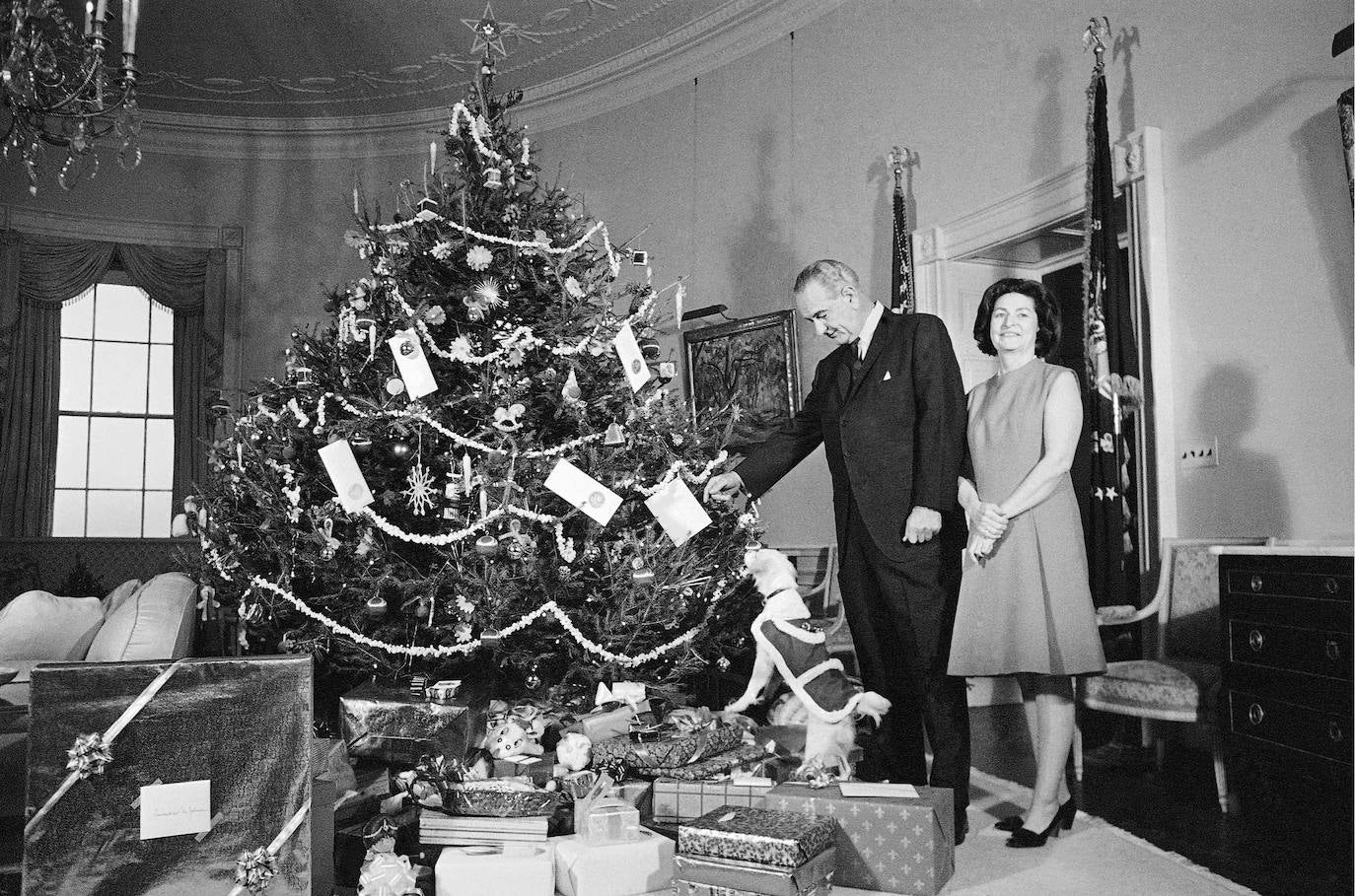 Lyndon B. Johnson, Lady Bird Johnson y Yuki, la mascota de la Casa Blanca, posan junto al árbol de Navidad de la familia