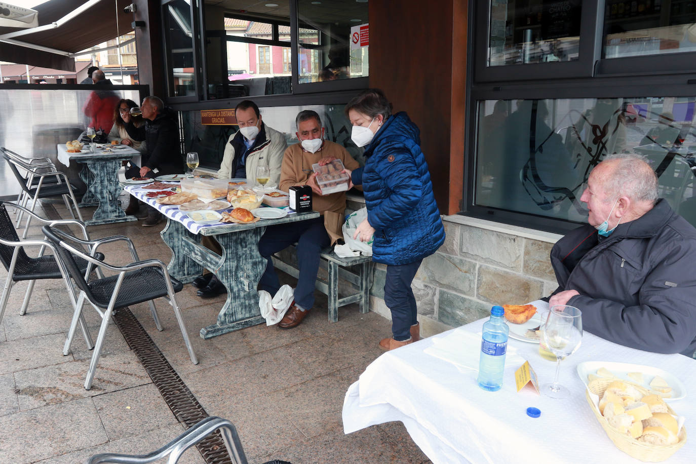 Los vecinos de Pola de Siero celebran la fiesta de Les Comadres condicionados por el cierre perimetral | Los restaurantes elaboran menús para llevar y los bares regalan bollos para animar hoy, y pese a las restricciones, la celebración