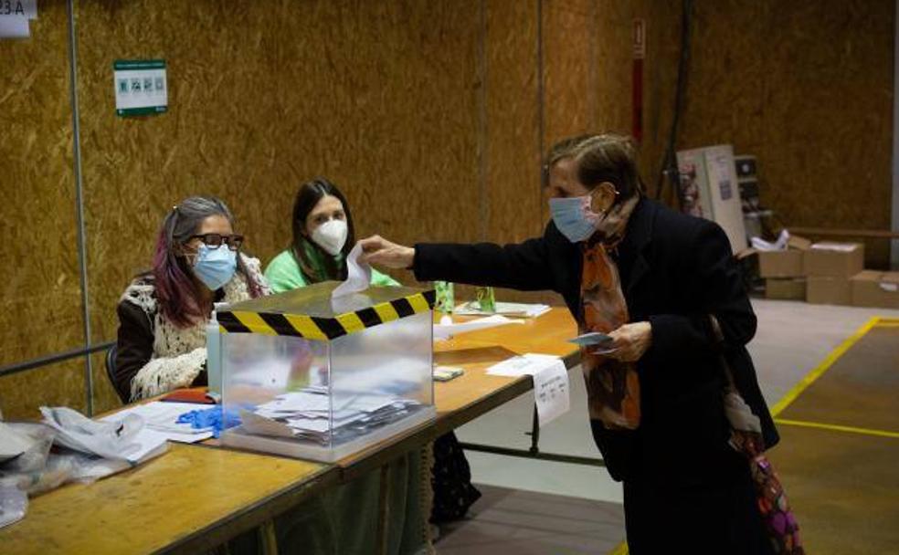 Una mujer vota en una mesa electoral del Polideportivo Tres Xemeneies, en Barcelona.