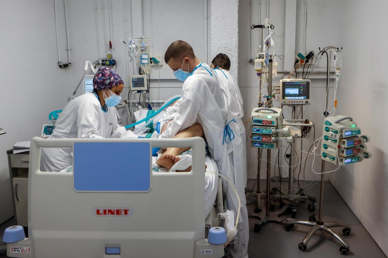 Sanitarios mueven a un paciente de covid-19 en la UCI del Hospital de Sabadell. 