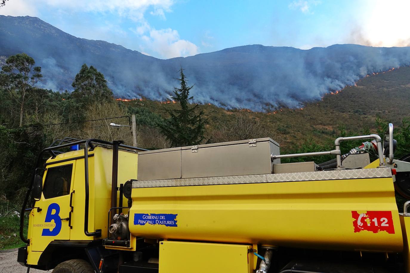 Los bomberos tratan de controlar el fuego activo en la sierra de Las Pandas-Cubera, en el límite entre los dos concejos del Oriente.