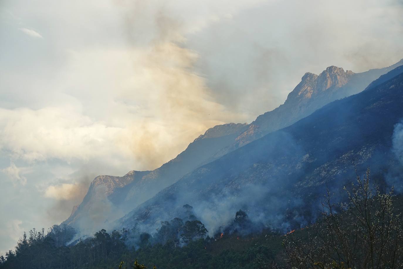 Los bomberos tratan de controlar el fuego activo en la sierra de Las Pandas-Cubera, en el límite entre los dos concejos del Oriente.