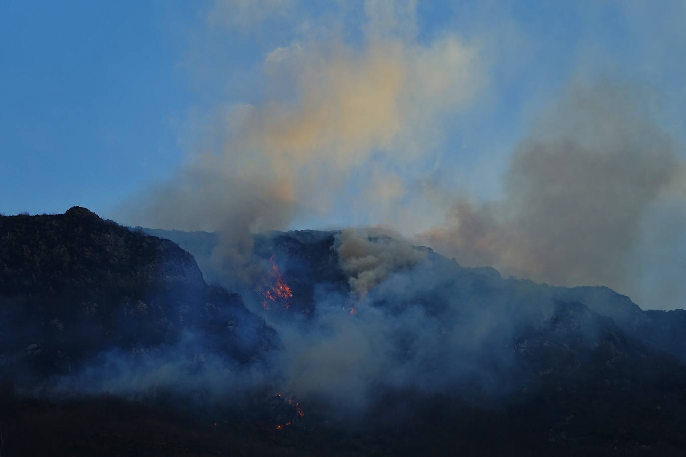 Los bomberos tratan de controlar el fuego activo en la sierra de Las Pandas-Cubera, en el límite entre los dos concejos del Oriente.