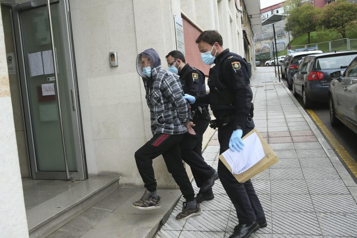 El supuesto atracador entrando ayer en el Juzgado de Siero escoltado por dos policías. 