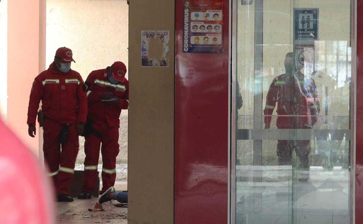 Varios bomberos inspeccionan el lugar del accidente el que murieron siete estudiantes, en El Alto (Bolivia)