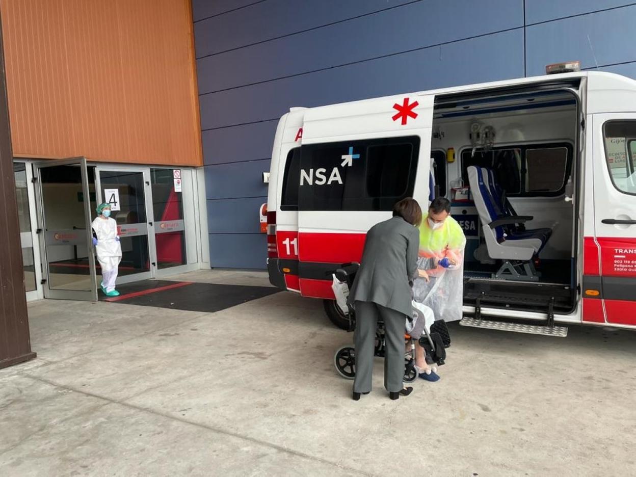 Un sanitario ayuda a una mujer gran dependiente a acceder a una ambulancia a la salida del hospital H144.
