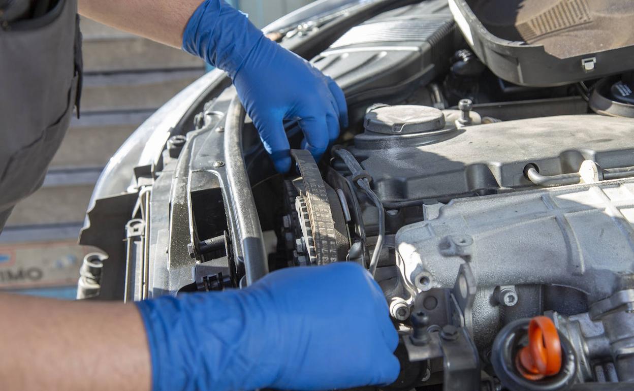 Un mecánico examina un vehículo. 