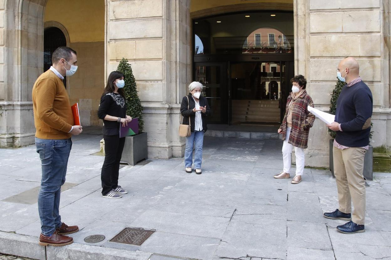 Rubén Pérez, Laura Tuero y Jesús Martínez, en primer plano, con dos portavoces la plataforma ITV en Granda No, Margarita Simón y Marian Rendueles, frente a la puerta del Consistorio. 