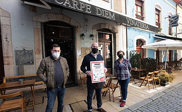 David Álvarez, Alberto Fernández y Raquel Díaz, integrantes de la plantilla de la vinatería Carpe Diem de Avilés, ayer, durante la protesta. En el vídeo, las reivindicaciones de los hosteleros en Gijón y Oviedo.