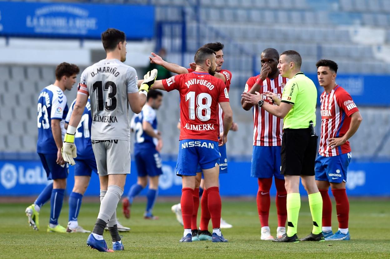 Los jugadores rojiblancos piden explicaciones a Iglesias Villanueva, ayer, durante el partido. 