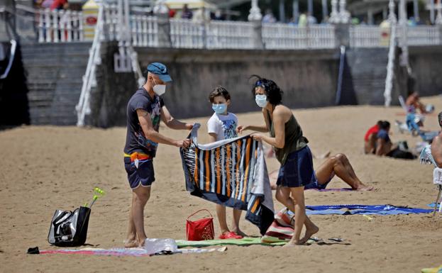 Varias personas pasean por Oviedo con mascarilla.