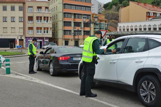 Varios agentes de la Guardia Civil controlan a los ocupantes de los vehículos en la orilla este de la ría de Ribadesella, a la salida del puente. 