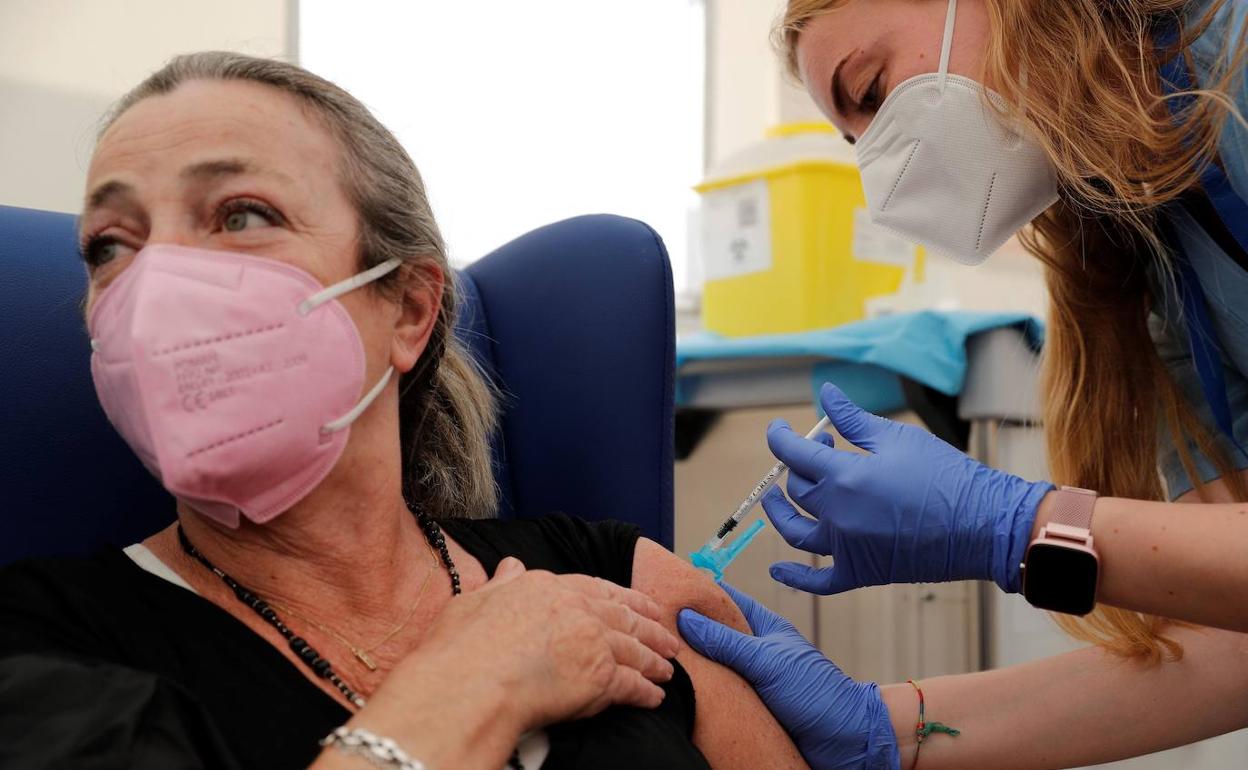 Una enfermera vacuna a una mujer en el Hospital de La Fe de Valencia.