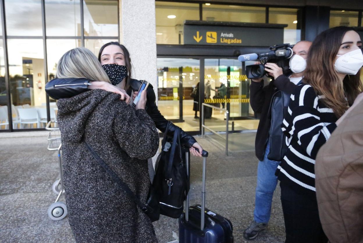 Una joven se despide de su familia en el aeropuerto. 