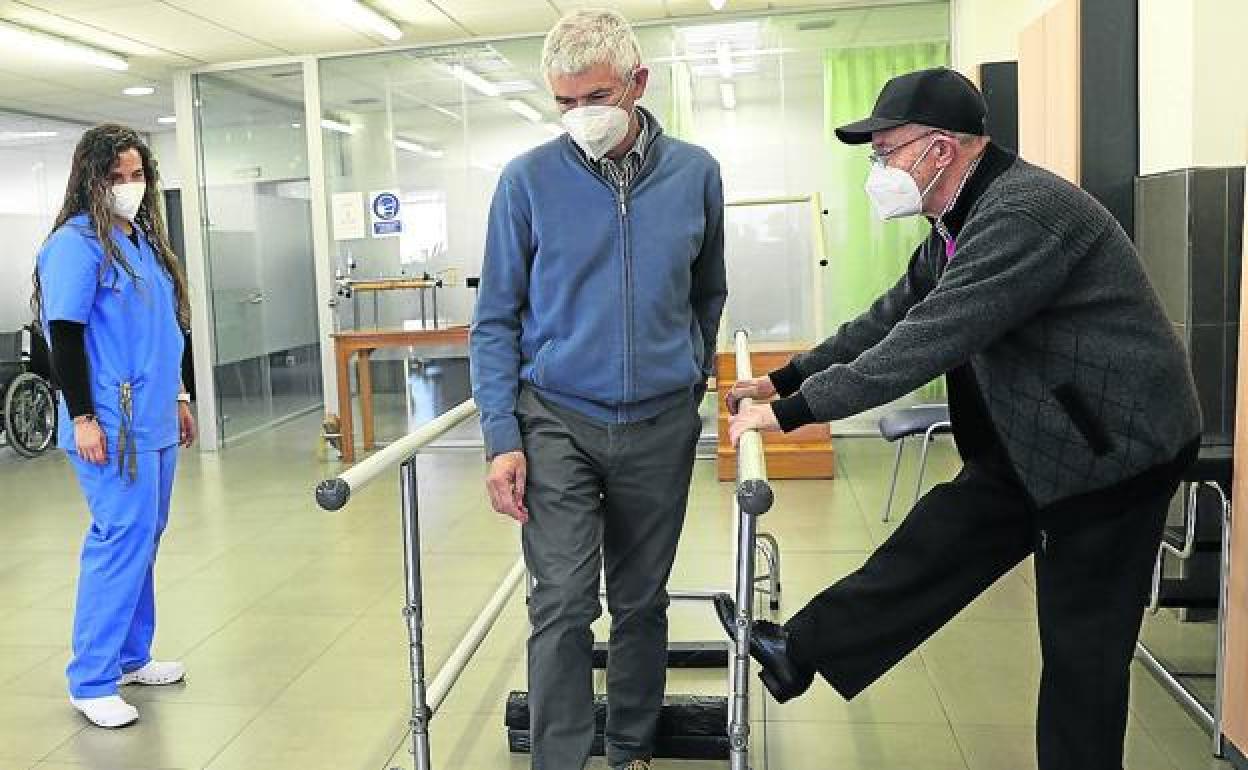 Juan Antonio Llorente y José Lombardía, en la zona de rehabilitación de la Asociación Parkinson Jovellanos, en presencia de Sandra, la logopeda. 