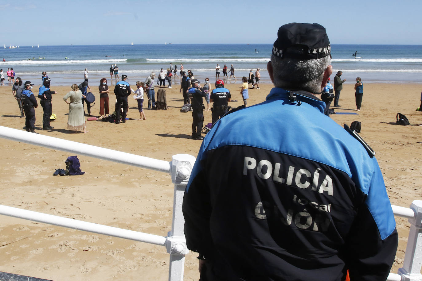 Amplio dispositivo policial en la mañana de este sábado en la playa de San Lorenzo para disolver a un grupo de personas que permanecía en el arenal sin mascarilla. Fueron obligados por los agentes a ponerse las protecciones.