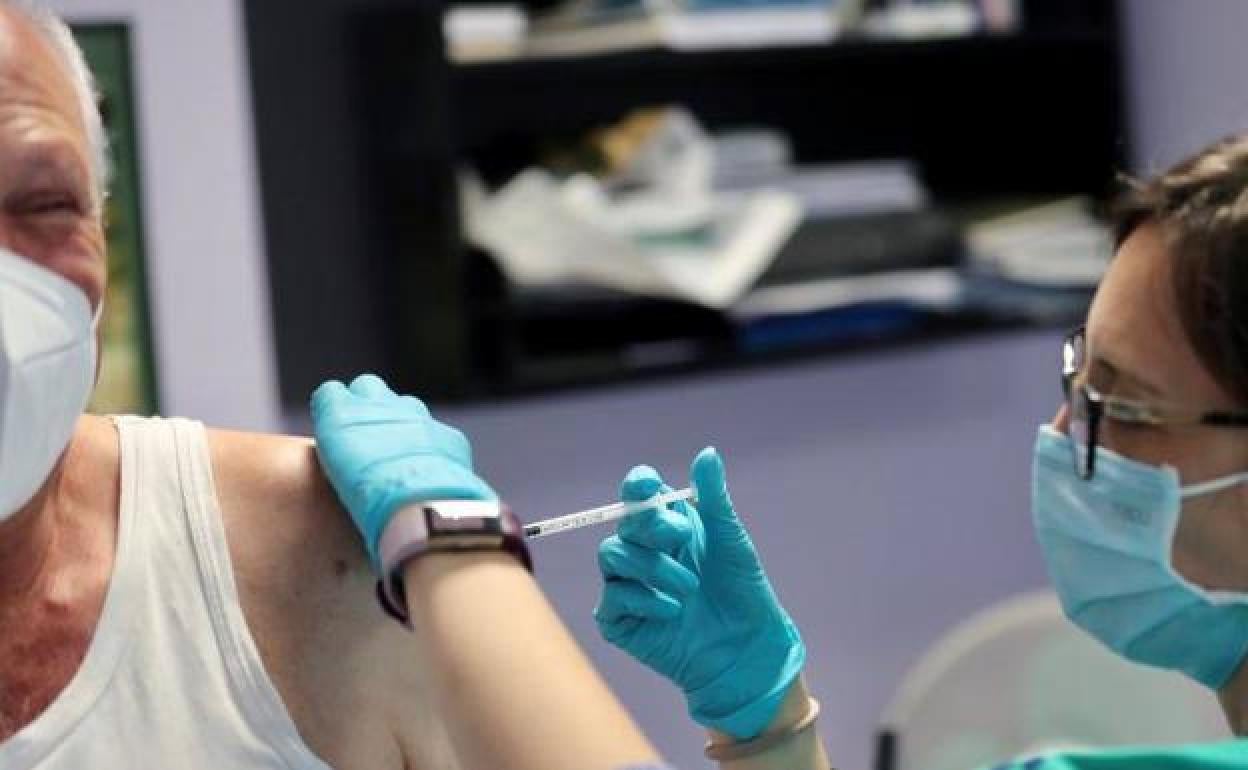 Un hombre se vacuna en Gijón. 