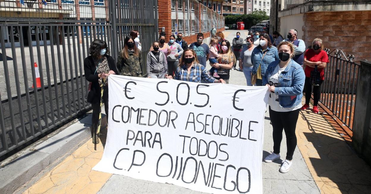 Las familias del colegio Narciso Sánchez, ayer, a las puertas donde protestaron para exigir un «comedor asequible para todos». 