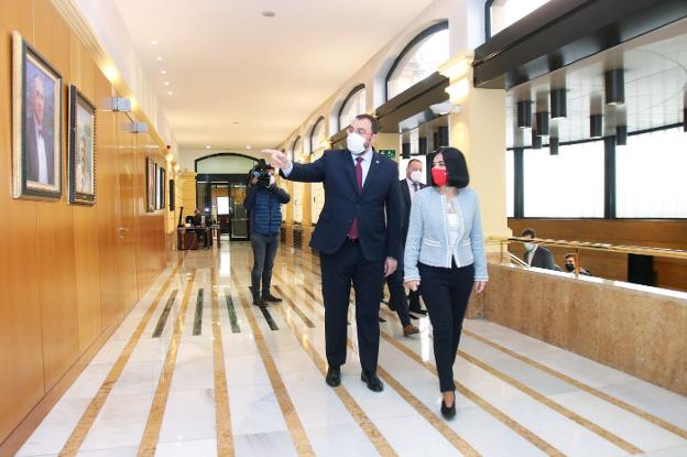 El presidente del Principado, Adrián Barbón, muestra a la ministra Carolina Darias la galería de retratos de los anteriores jefes del Ejecutivo en el Palacio de Presidencia. 