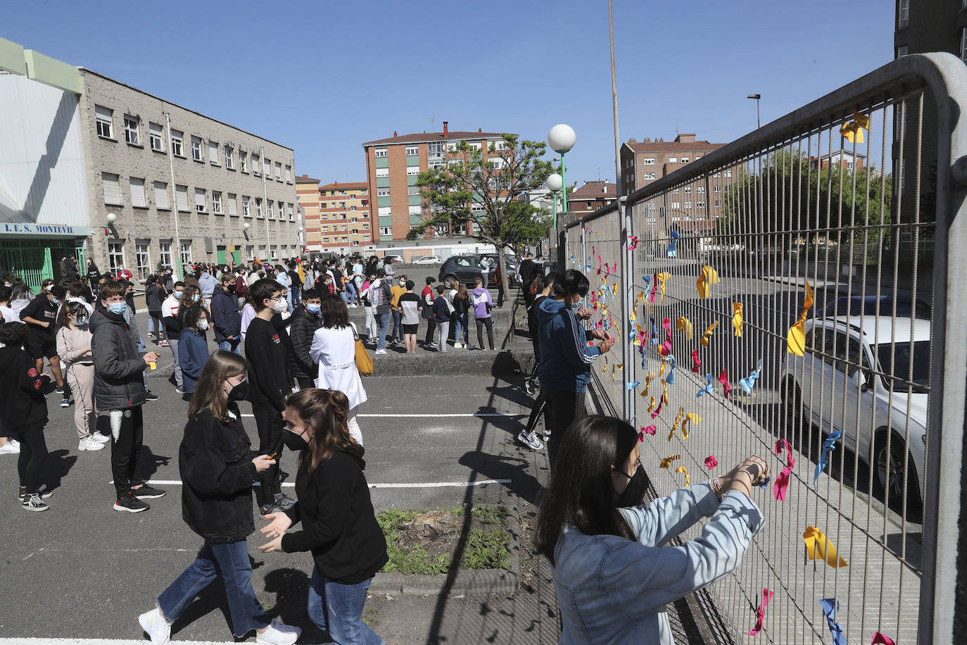 Un total de 150 alumnos han salido de sus clases para realizar un acto en el que los escolares han colocado lazos de colores, que contienen deseos formulados con la ilusión de un viaje, en la valla frontal del patio para formar una cadena de deseos entrelazados.