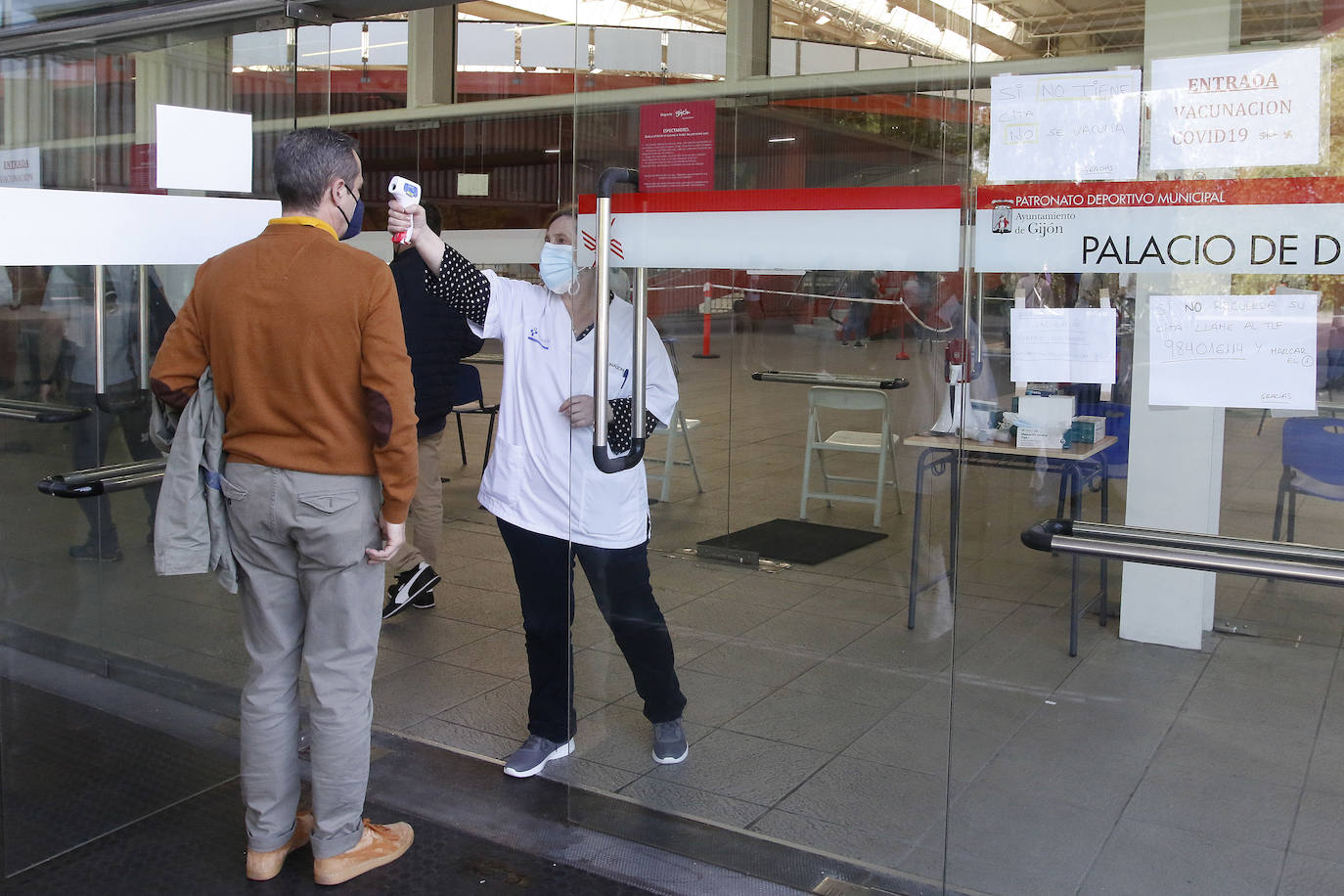 Gijón ha comenzado a vacunar contra la covid a la población de 59 años a un ritmo de 2.000 citados diarios. La primera jornada en el Palacio de Deportes se vio sobresaltada cuando una persona tuvo que ser atendida al sentirse indispuesta mientras esperaba para recibir la dosis.