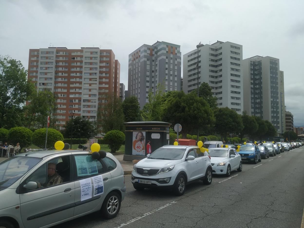Los vehículos que participaron en la protesta por el abuso de la temporalidad, a su paso por la calle Carlos Marx de Gijón. 