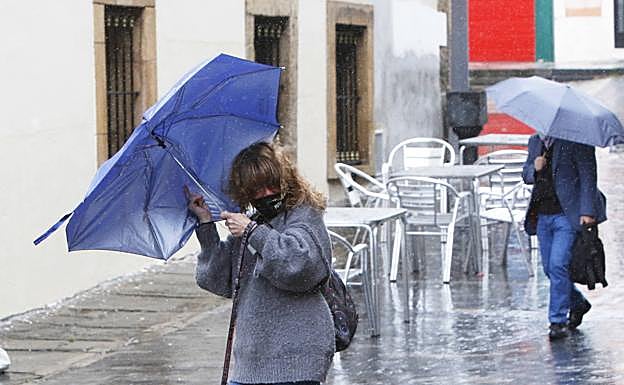 Imagen. El viento y la lluvia sorpreden a los gijoneses