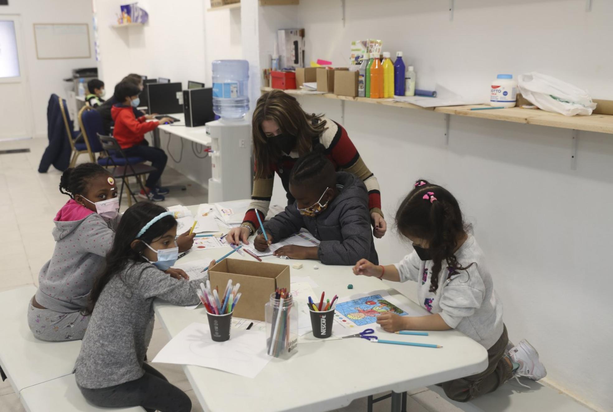 Un grupo de niños hace sus tareas escolares en el centro de apoyo. 