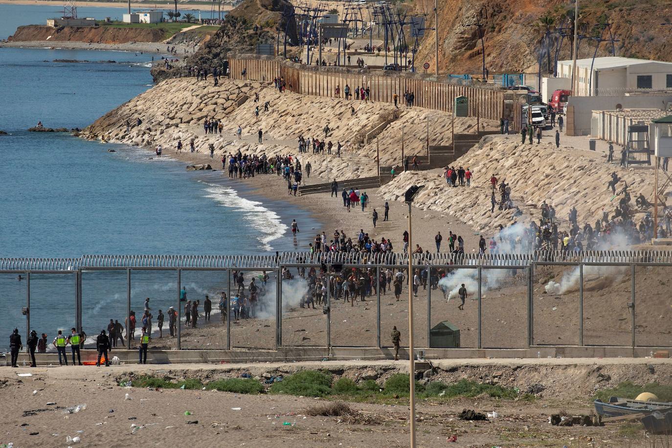  Por segundo día consecutivo, Ceuta ha vivido una crisis migratoria que está dejando datos e imágenes escalofriantes. En la costa ceutí se ha visto la llegada de miles de personas exhaustas, entre ellos jóvenes y niños, tras lanzarse al mar desde Marruecos para tratar de llegar a territorio español, ante la impasibilidad de los militares marroquíes. Algunas de estas personas han tenido que utilizar botellas de plástico a modo de flotador y otras han tenido que ser atendidas en la playa por las Fuerzas y Cuerpos de Seguridad y por voluntarios. 