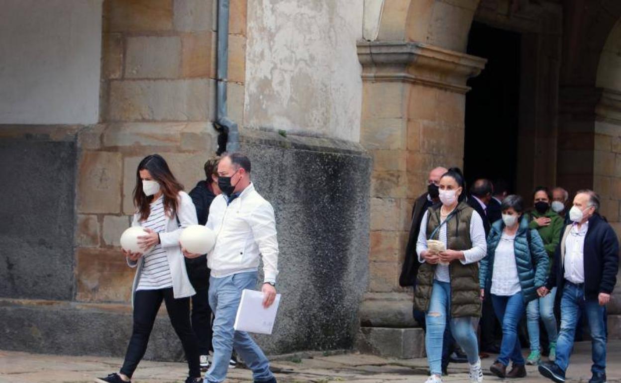 Familiares y allegados con las cenizas de las fallecidas a la salida del funeral oficiado en la iglesia parroquial de Santa María de Sábada, en Lastres. 