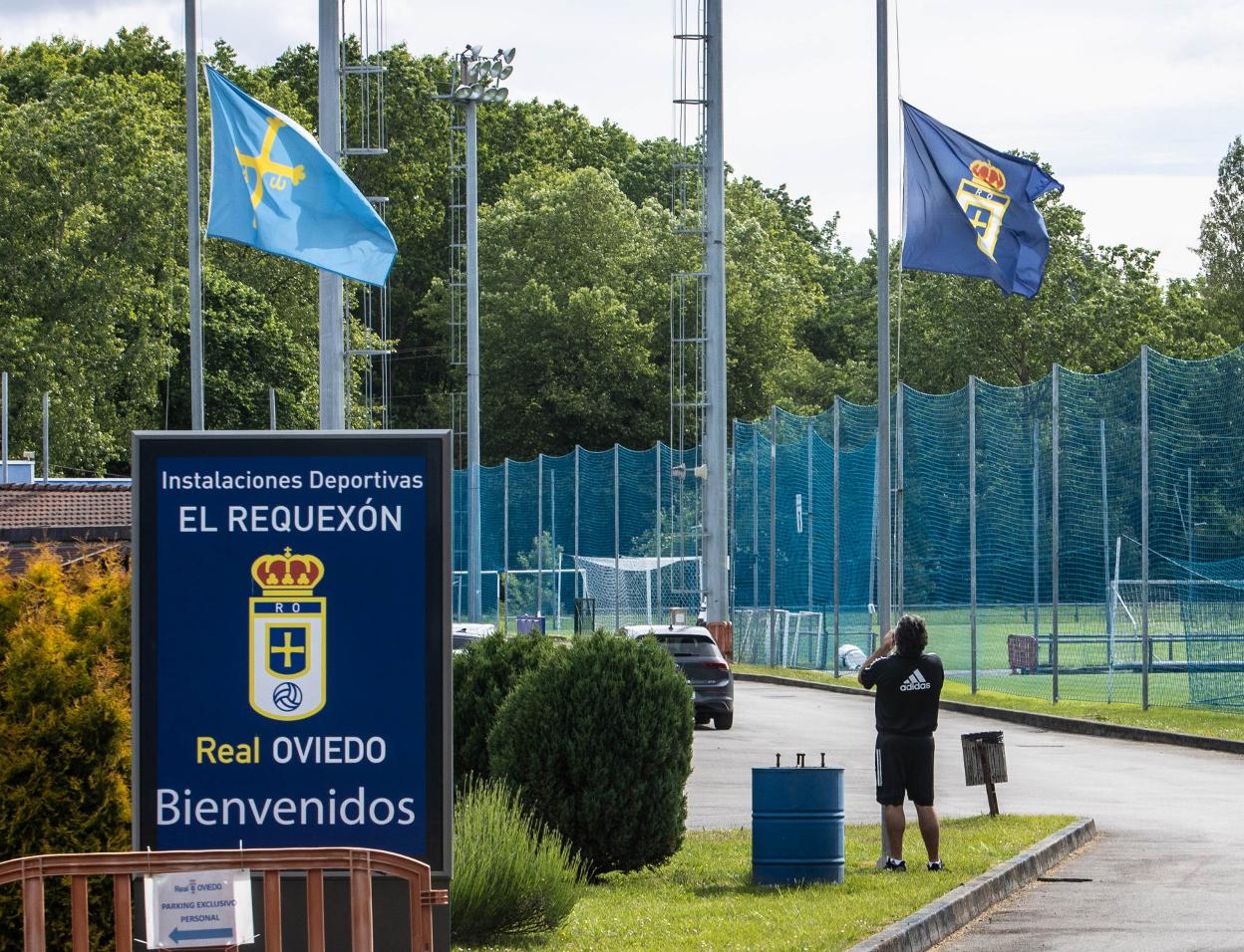 Un trabajador coloca la bandera del Oviedo a media asta, ayer, en El Requexón. 