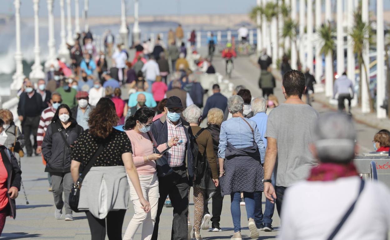 Gente de paseo por el muro de Gijón