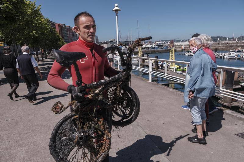 Con motivo del Día Mundial del Medioambiente, una veintena de buzos voluntarios procedió a retirar los residuos del fondo marino de la dársena interior del Puerto Deportivo de Gijón. Llegaron a sacar a tierra baterías, carros de la compra y hasta una bicicleta.