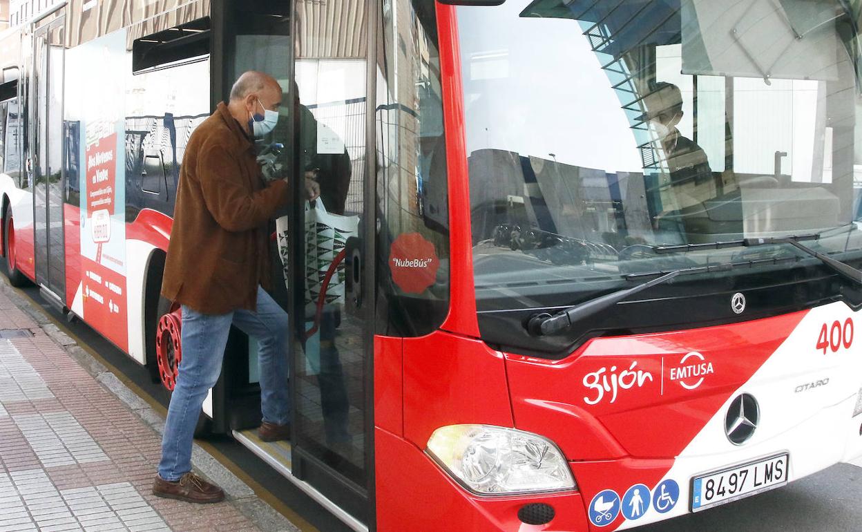 Un usuario sube al autobús en Gijón. 