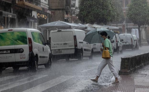 Galería. Una señora se protege de la lluvia con un paraguas en Oviedo.