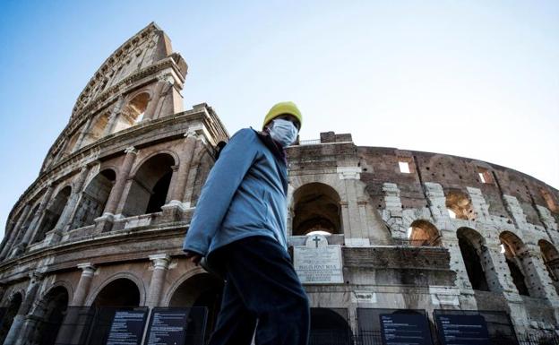 Un turista se protege con una mascarilla en el Coliseo romano. 