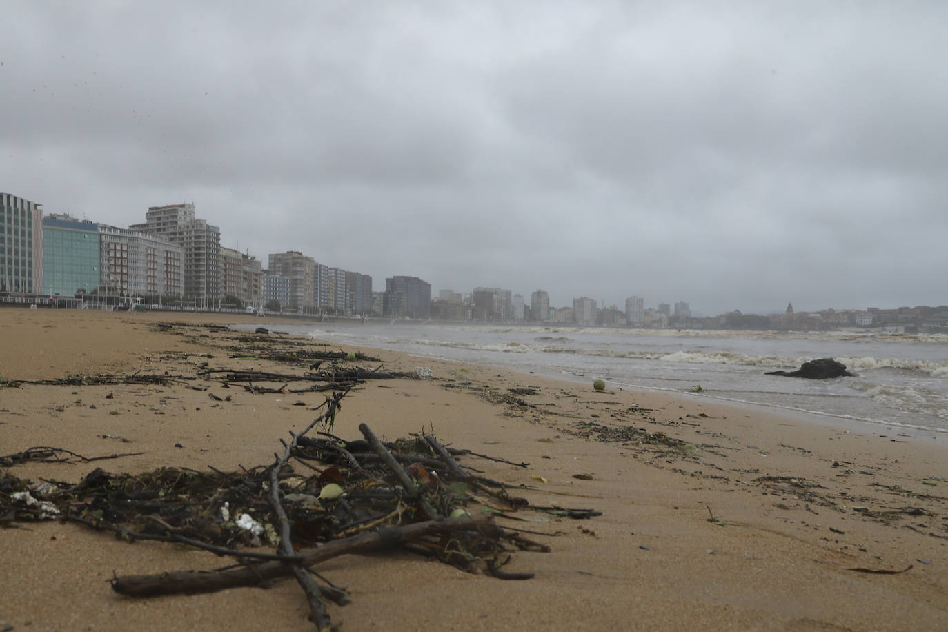 Gijón cierra al baño el tramo entre las escaleras 12 y 15 de la playa de San Lorenzo por los alivios al río Piles provocados por el temporal de lluvias. 