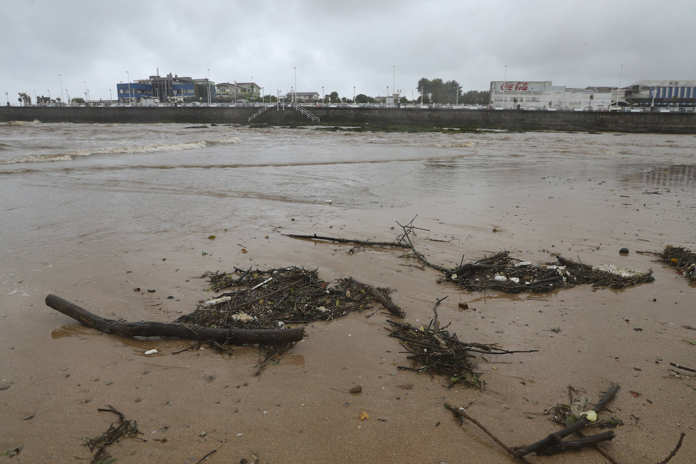 Gijón cierra al baño el tramo entre las escaleras 12 y 15 de la playa de San Lorenzo por los alivios al río Piles provocados por el temporal de lluvias. 