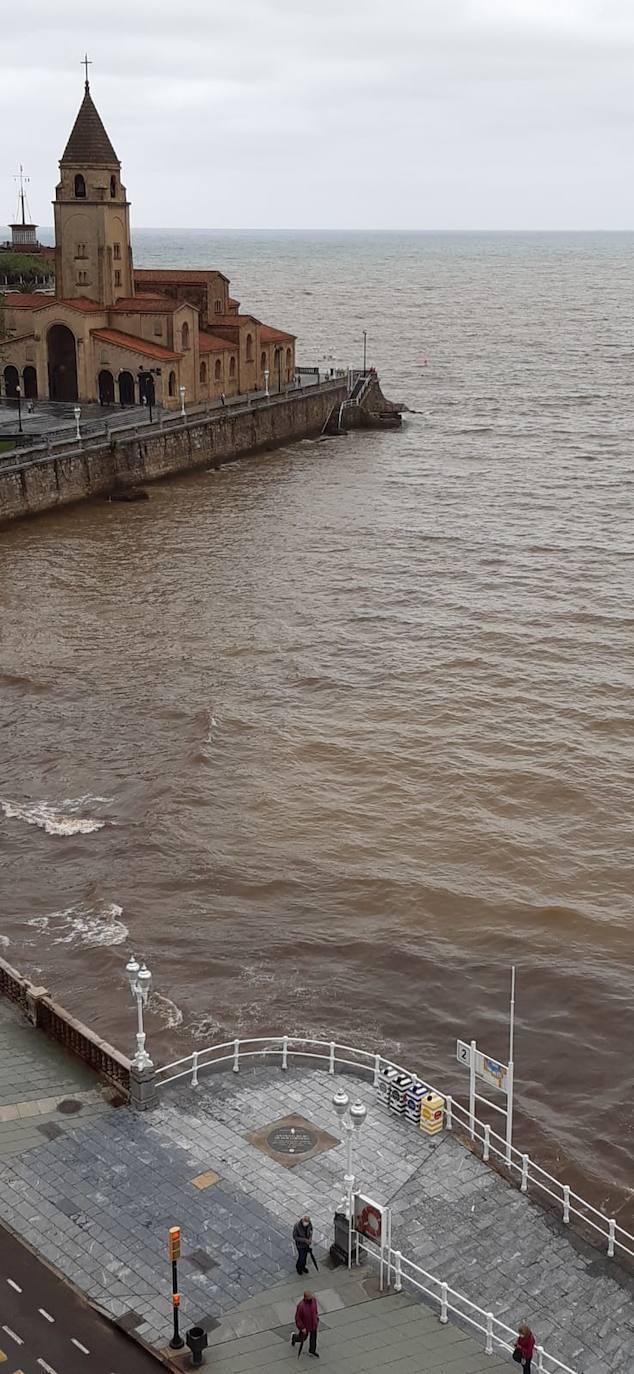 Gijón cierra al baño el tramo entre las escaleras 12 y 15 de la playa de San Lorenzo por los alivios al río Piles provocados por el temporal de lluvias. 