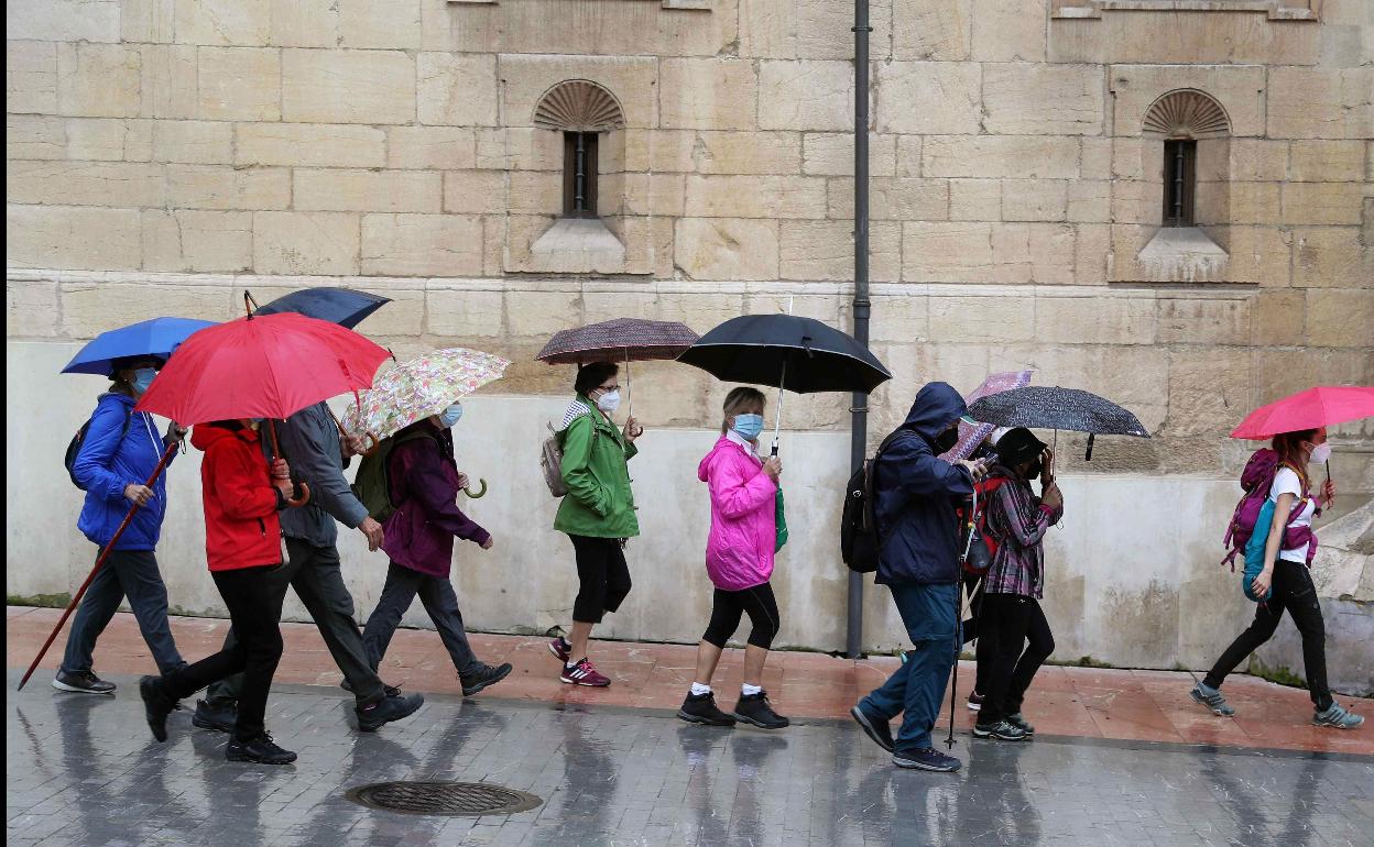 Un grupo de peregrinos se protege de la lluvia en Oviedo.