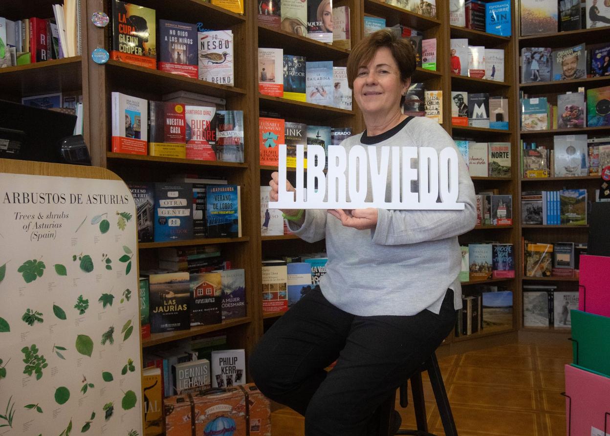 Mar Prieto posa con el cartel de LibrOviedo en su librería. 