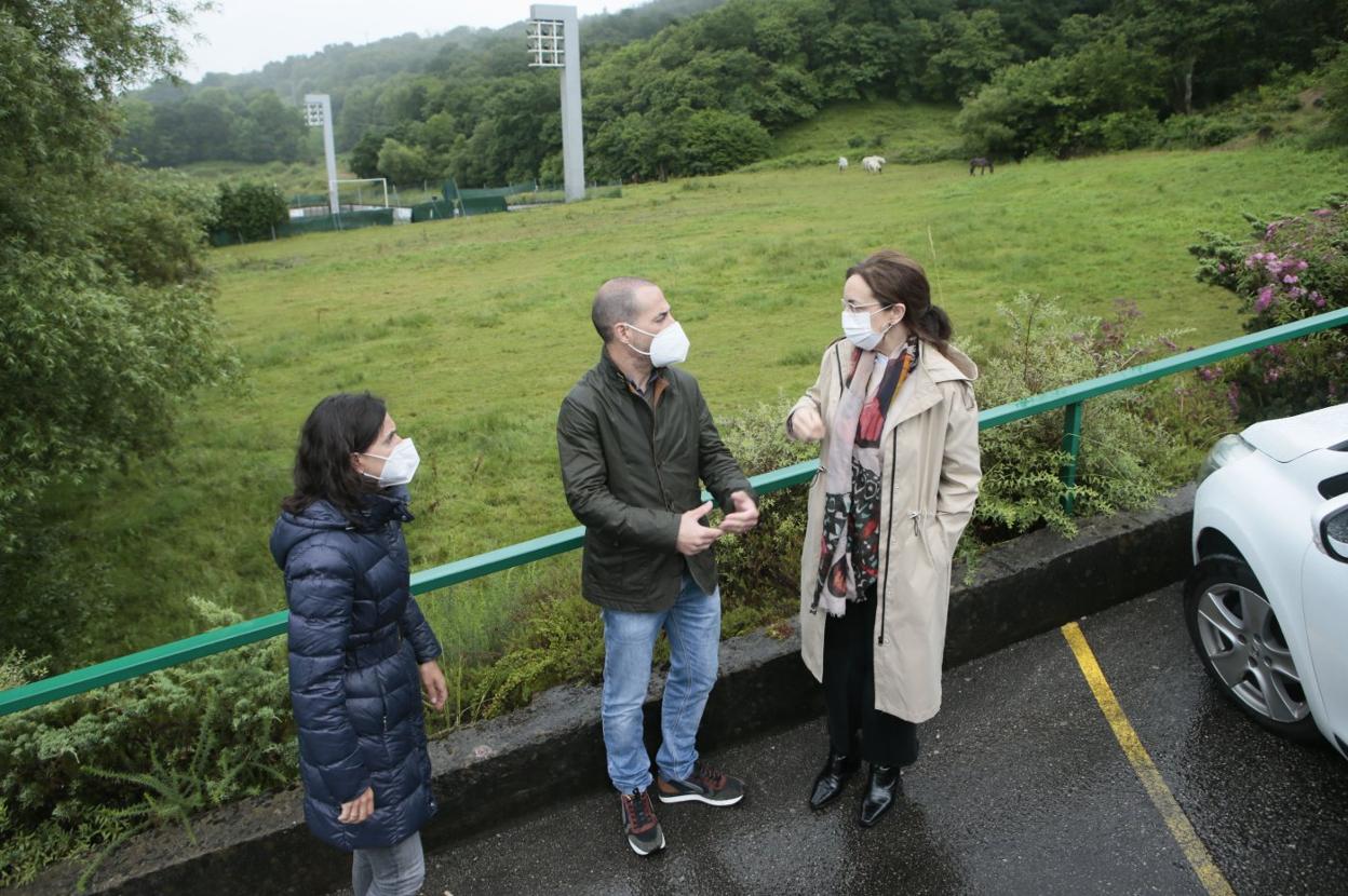  La edil Aida Nuño, el alcalde, Ángel García, y la gerente de Cogersa, Paz Orviz; tras ellos la parcela cedida. 