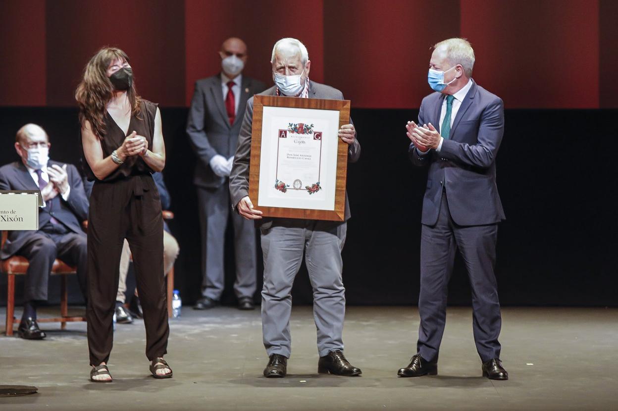 José Antonio Rodríguez Canal, con la distinción, aplaudido por Laura Tuero y Aurelio Martín.